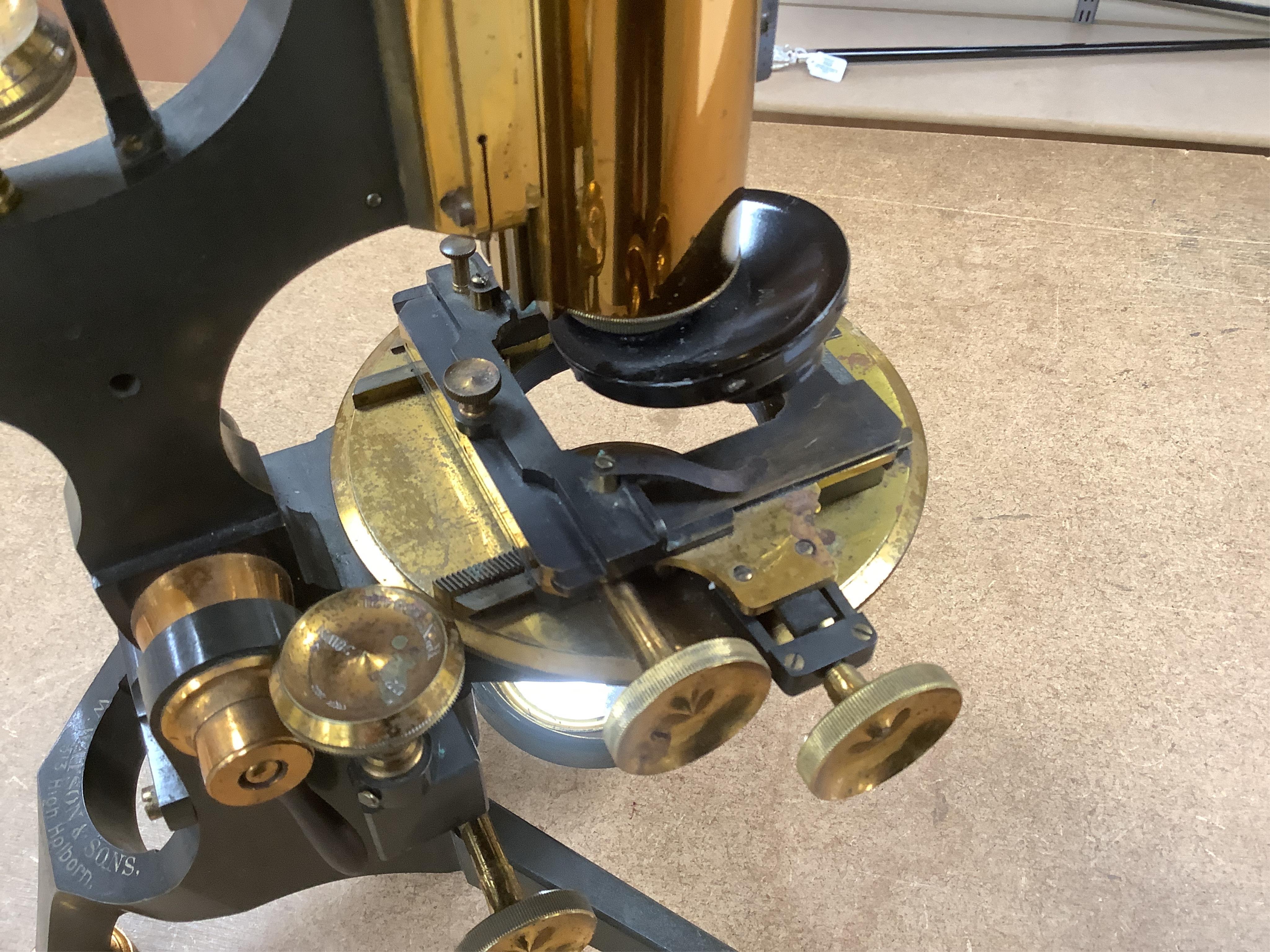 A late 19th/early 20th century brass microscope, by Watson and Sons, in a fitted case with some alternative lenses and other accessories, case 39.5cm high. Condition - fair